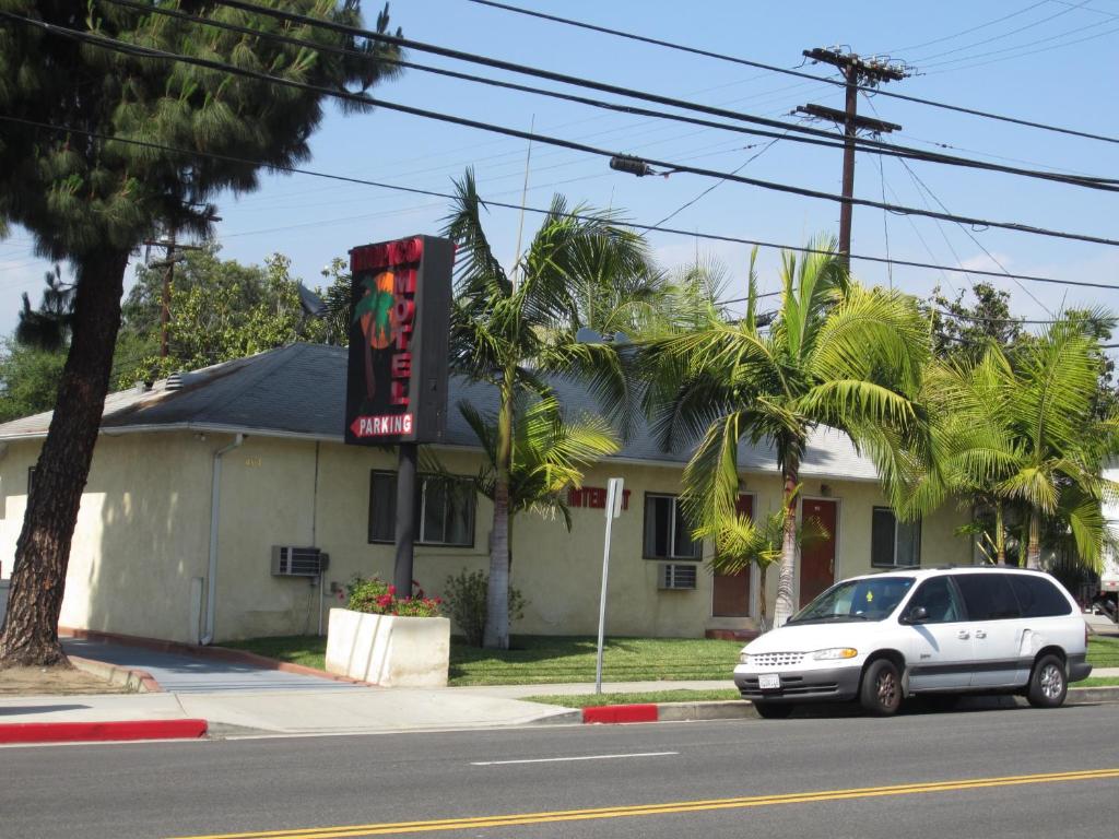 een witte auto geparkeerd voor een gebouw bij Tropico Motel in Glendale