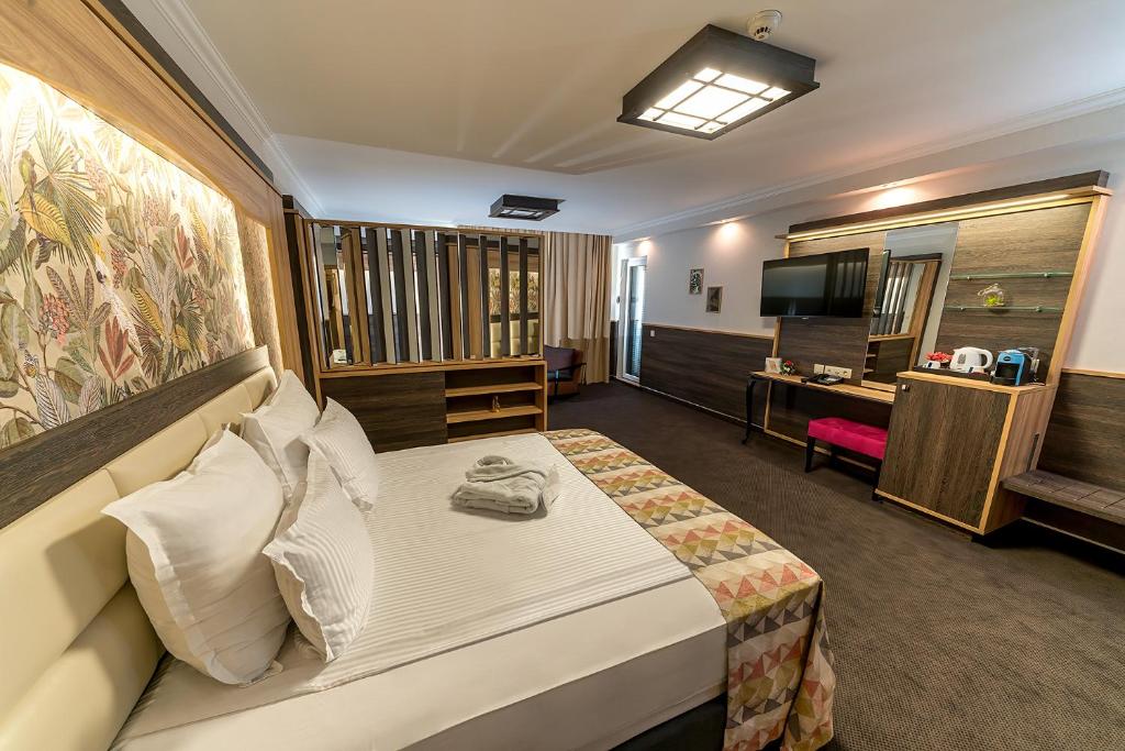 ソフィアにあるHotel ZOO Sofia - Secured Paid Parkingのベッドとテレビが備わるホテルルームです。