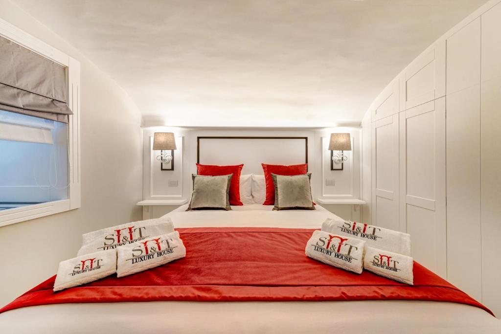 um quarto com uma cama grande e almofadas vermelhas em S&T LUXURY HOUSE in PLEBISCITO SQUARE em Nápoles