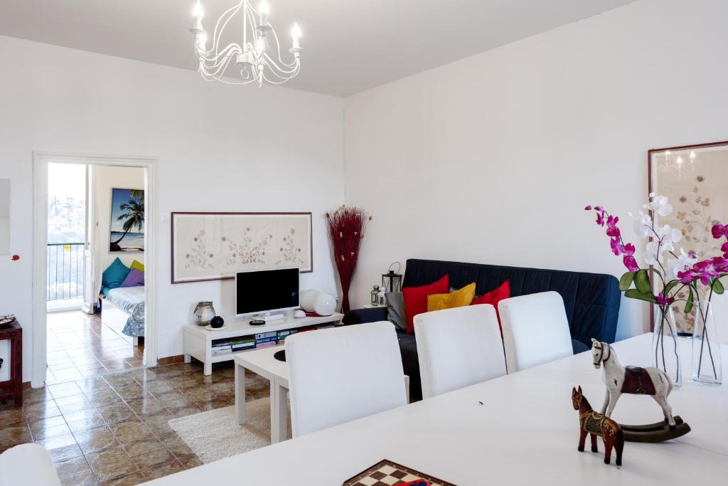 Biały salon z białym stołem i krzesłami w obiekcie Le Viole Matte - Appartamento immerso nel Verde con Vista Mare w mieście La Spezia