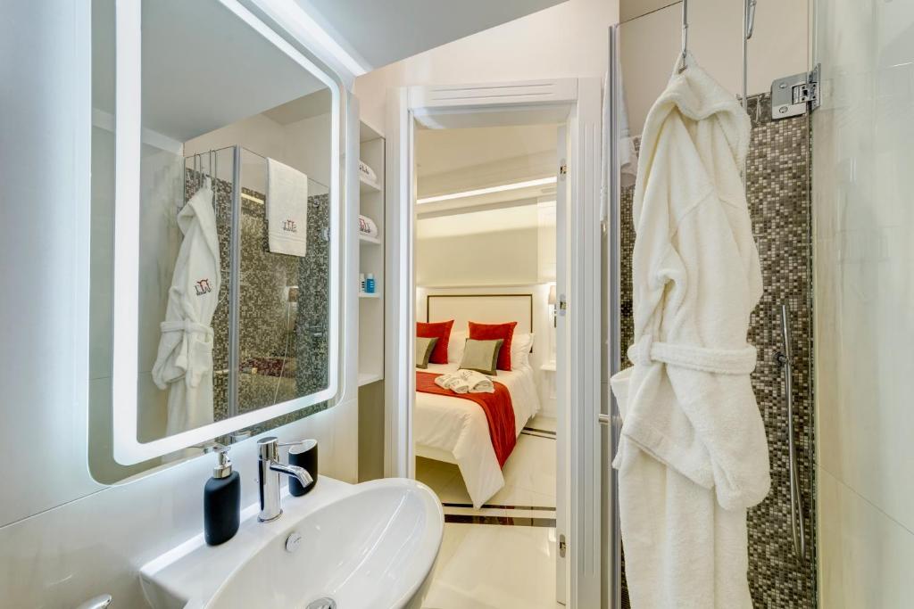 łazienka z umywalką, lustrem i łóżkiem w obiekcie S&T LUXURY HOUSE in PLEBISCITO SQUARE w mieście Neapol