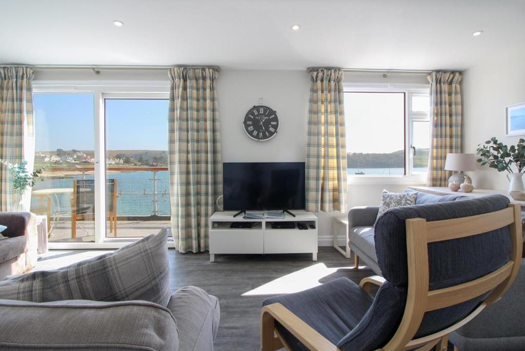 
a living room filled with furniture and a large window at Careema in Saint Mawes
