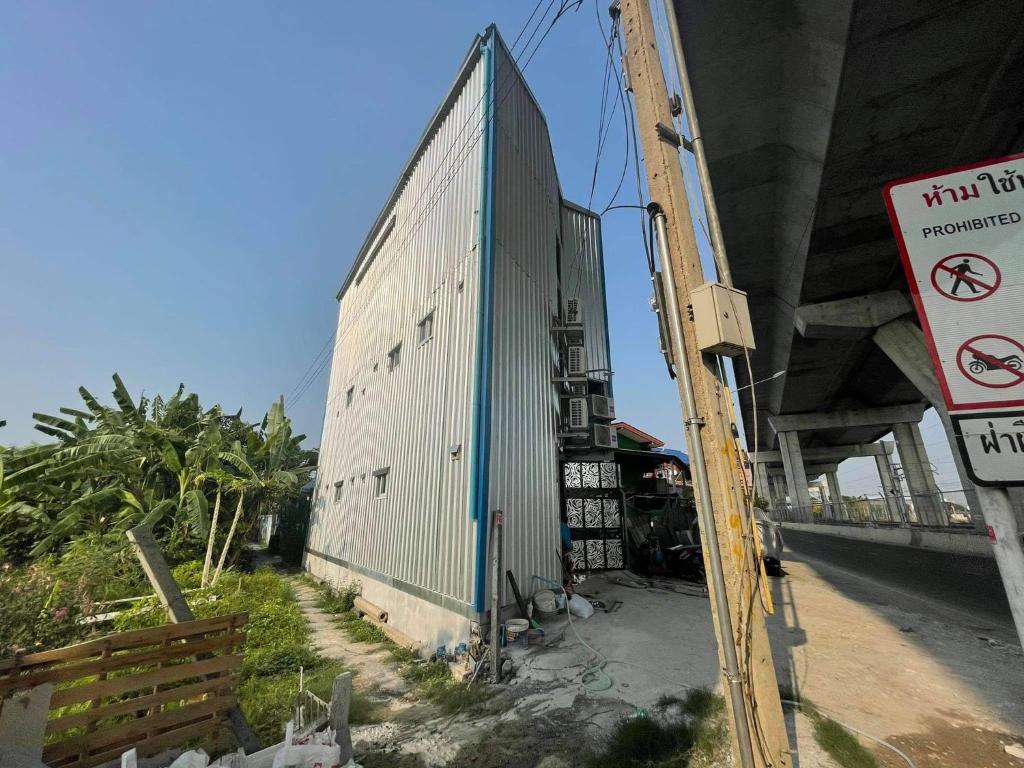 a building that is next to a highway at Charinsup Pinklao Hotel in Bang Kruai