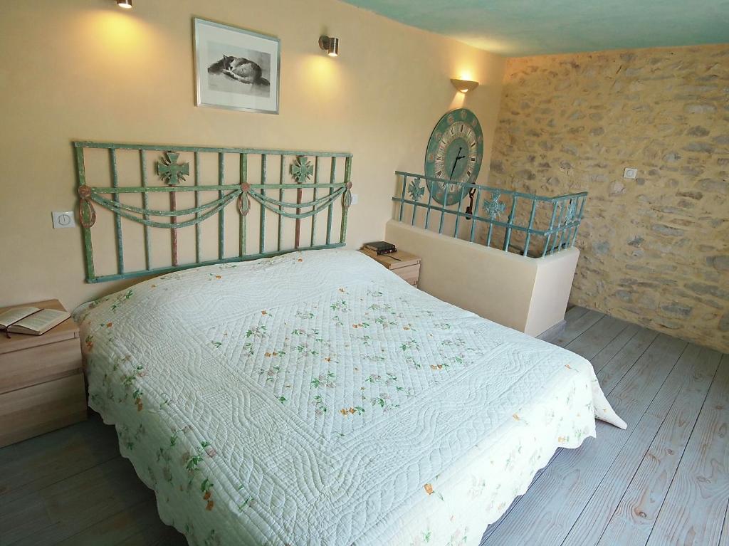 a bedroom with a bed with a white comforter at La Grange de la Lavande in Lardiers
