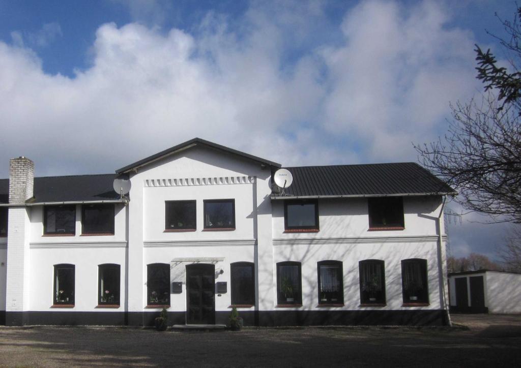 a white building with a black roof at Ferienwohnung Birkwang in Wanderup