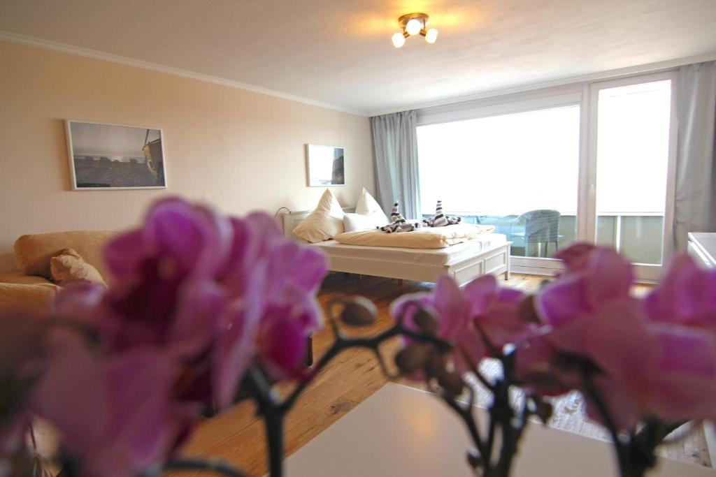 ein Wohnzimmer mit lila Blumen im Vordergrund in der Unterkunft Ferienwohnung Sternenlicht in Westerland