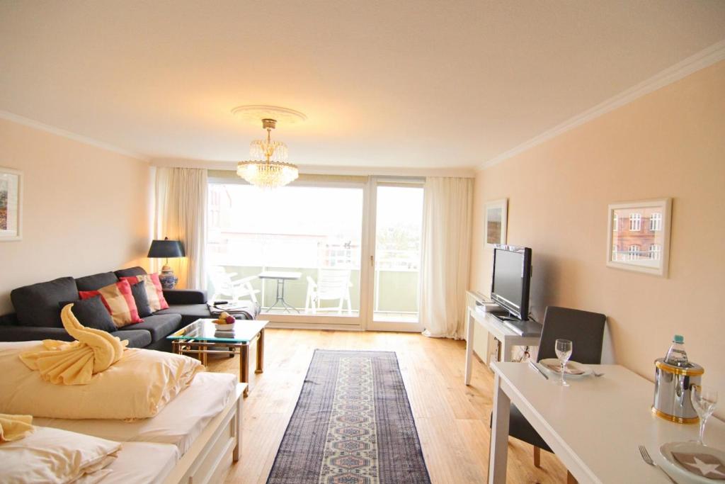 ein Wohnzimmer mit einem Sofa und einem TV in der Unterkunft Apartment Di Wiis in Westerland