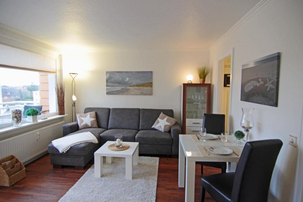 ein Wohnzimmer mit einem Sofa und einem Tisch in der Unterkunft Ferienwohnung Austernmuschel in Westerland