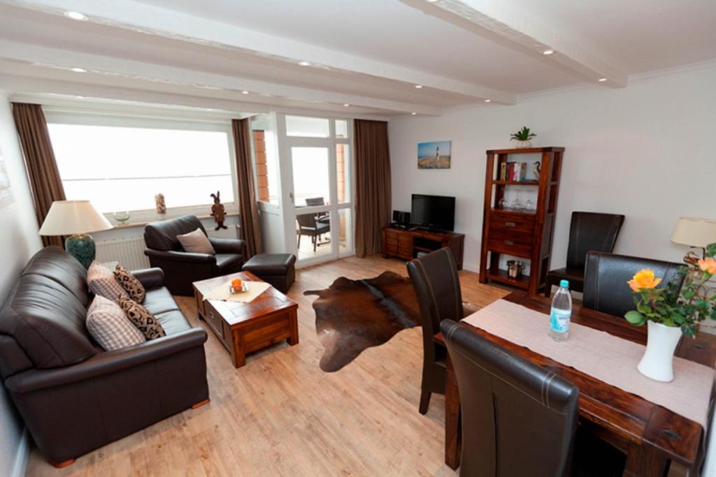 ein Wohnzimmer mit einem Sofa und einem Tisch in der Unterkunft Ferienwohnung Dünenblick in Westerland