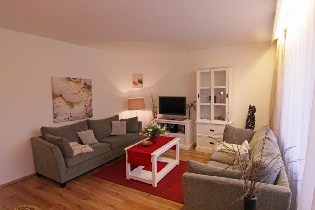 un salon avec un canapé et une table dans l'établissement Haus Heidi, à Westerland