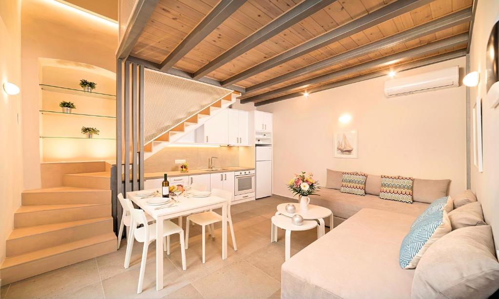 Pal Calma Suites في مدينة ريثيمنو: مطبخ وغرفة معيشة مع طاولة وأريكة