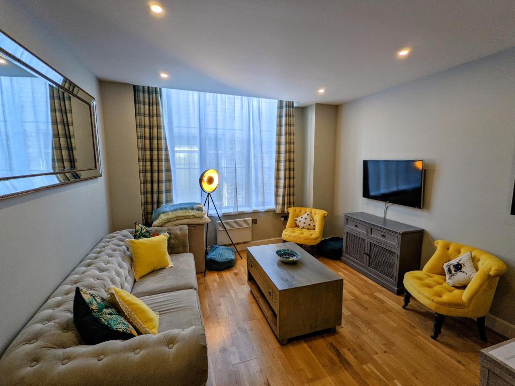 a living room with a couch and a tv at Heart of the City - FREE PARKING in York