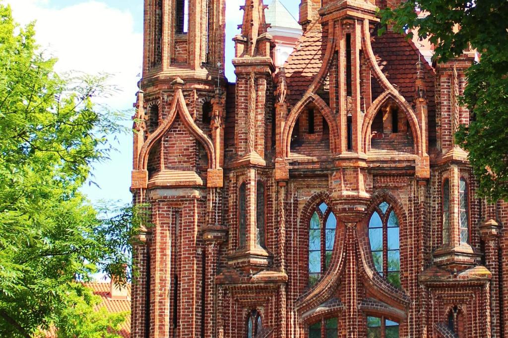 a tall brick building with a tower and windows at St Anne studio in Vilnius