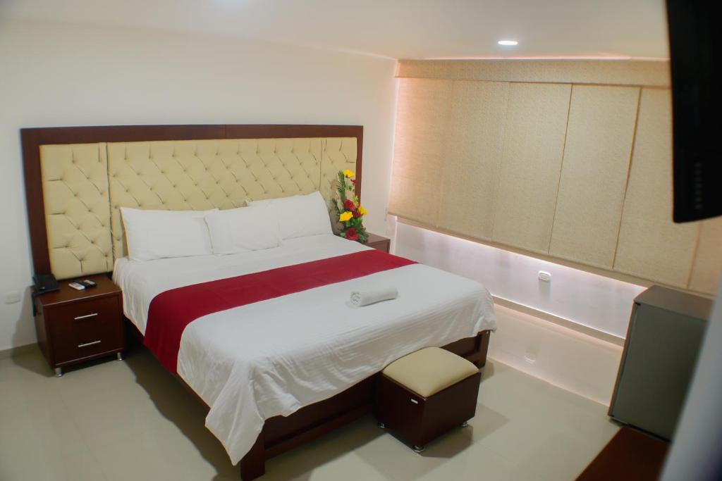 1 dormitorio con 1 cama grande con manta roja y blanca en Hotel Las Vegas RB, en Ríohacha