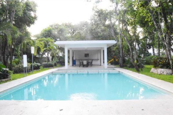 a large blue swimming pool with a pavilion in a yard at La Casa del Arbol -4bed 3 bath in Puerto Morelos