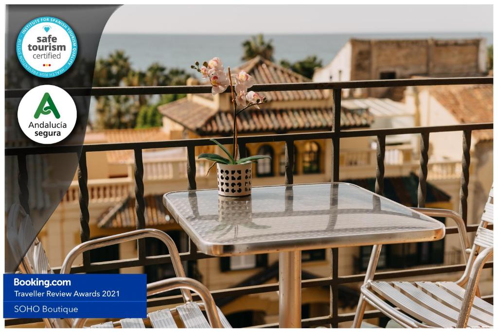 a table on a balcony with a plant on it at Soho Boutique Los Naranjos in Málaga