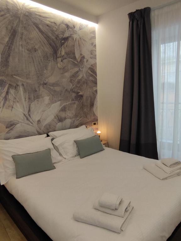 a bed with a white comforter and white pillows at Il Meraviglioso Mondo di Amélie in Agrigento