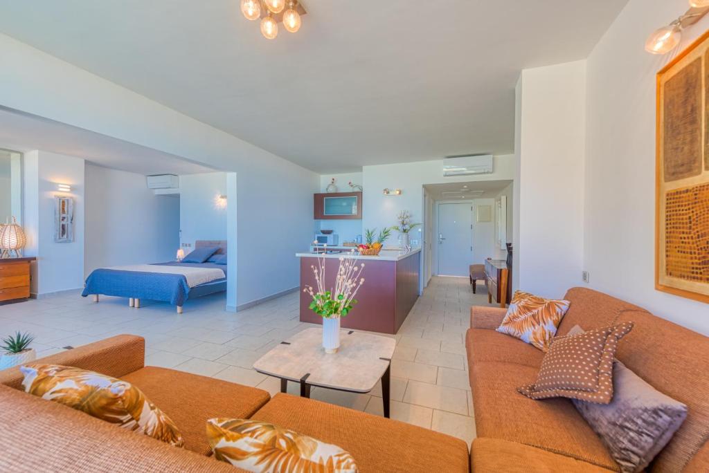 a living room with two couches and a kitchen at Le Domaine Anse Marcel Beach Resort in Anse Marcel 