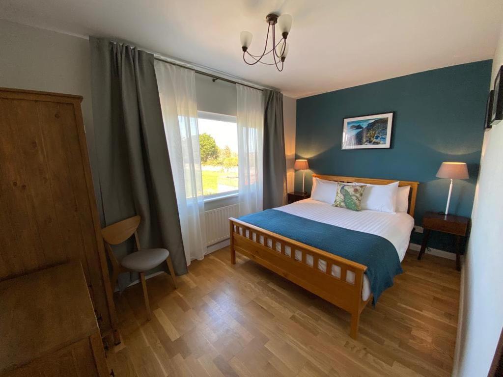 a bedroom with a bed and a large window at Parker House Beach & Golf Portrush in Portrush