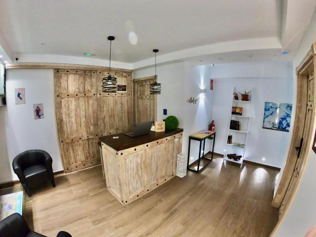 sala de estar con paredes de madera y escritorio en El refugio, en Pinos Genil