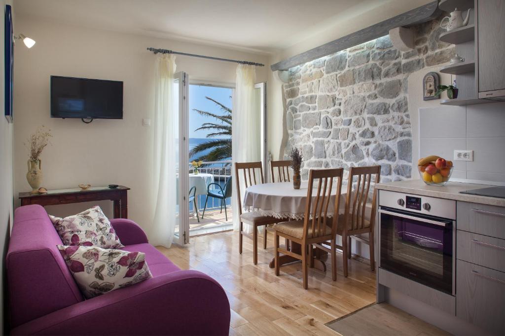 ein Wohnzimmer mit einem lila Sofa und einem Tisch in der Unterkunft Apartman Vite in Podgora