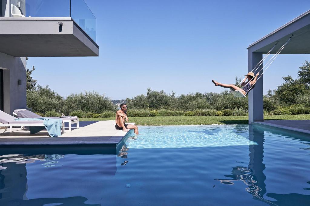 un hombre saltando al agua desde una piscina en The Designer's Villa - Member of Spiritual Living Corfu en Virós