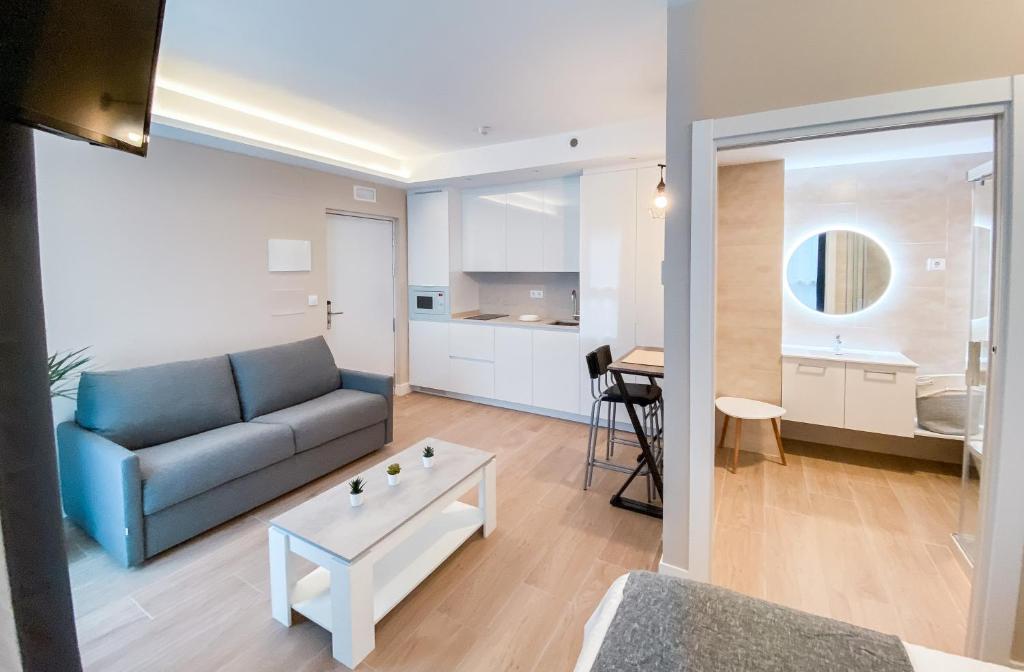 ein Wohnzimmer mit einem Sofa und einem Tisch in der Unterkunft Apartamentos Kai in Getxo