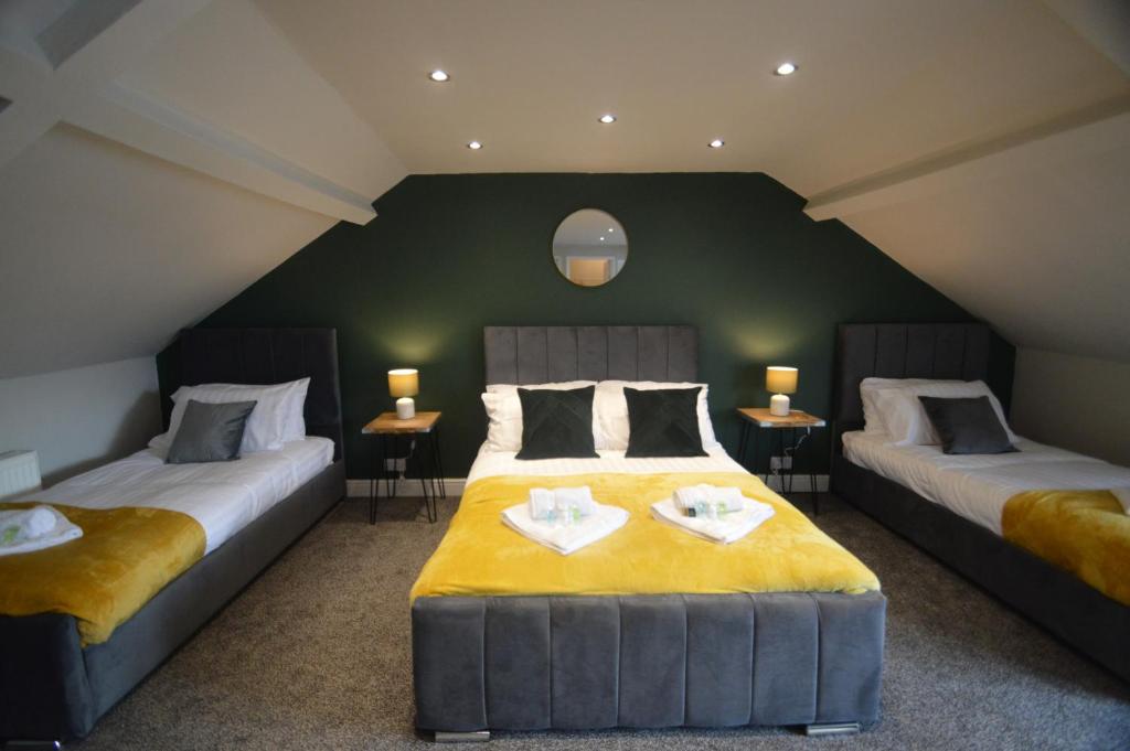 2 camas en una habitación con paredes verdes en Spacious and Homely 3 Bedroom Flat - SuiteLivin en Gateshead