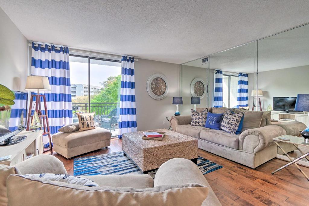 uma sala de estar com cortinas azuis e brancas e um sofá em Resort-Style Condo Located in Harbour Town! em Hilton Head Island
