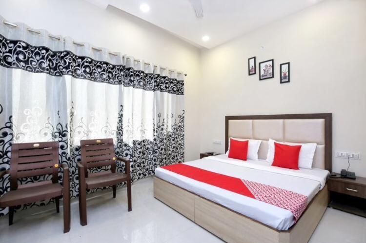 1 dormitorio con 1 cama grande y 2 sillas en Forever view near golden temple, en Amritsar