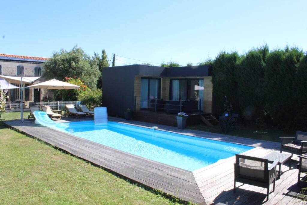 una piscina con sillas y una casa en Entre Piscine et Mer, en Tonnay-Charente