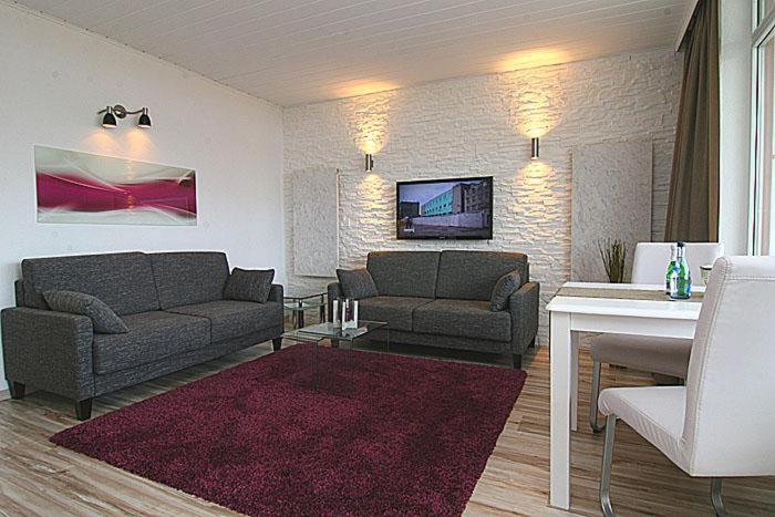 ein Wohnzimmer mit 2 Sofas und einem TV in der Unterkunft Ferienwohnung Ferlings in Hörnum