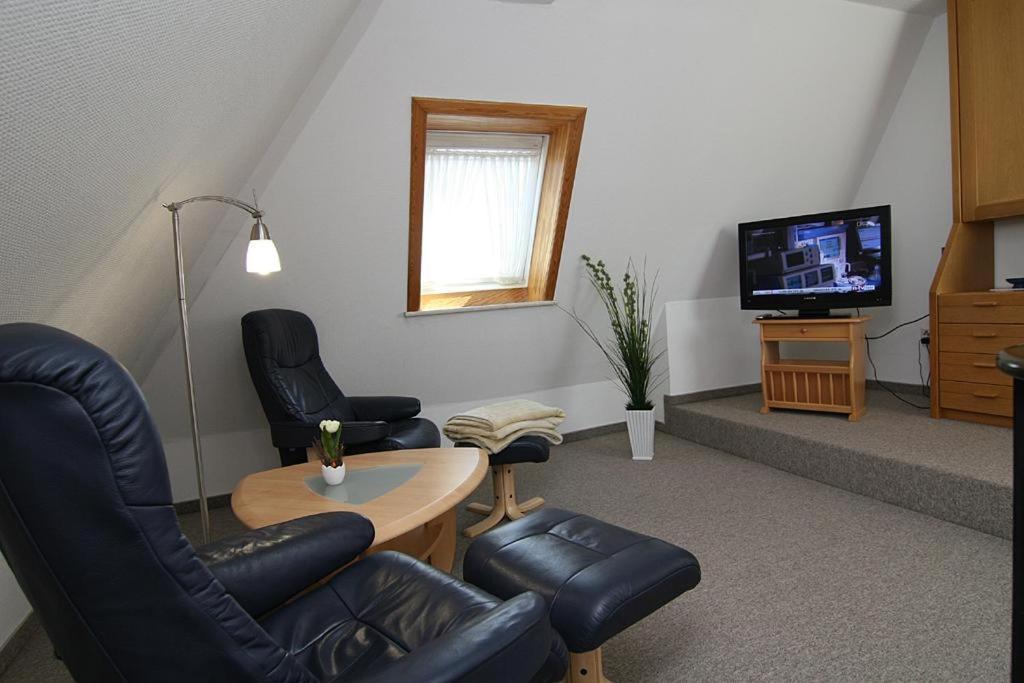 ヘルヌムにあるHaus Gräpel App 4のリビングルーム(椅子2脚、テーブル、テレビ付)