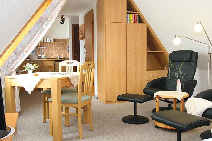 ヘルヌムにあるHaus Gräpel App 5のテーブルと椅子、キッチンが備わる客室です。