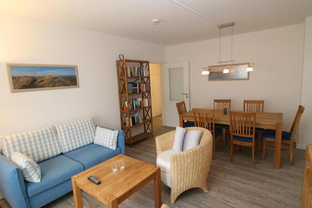 a living room with a couch and a dining room at Haus Möwe, Luig in Hörnum