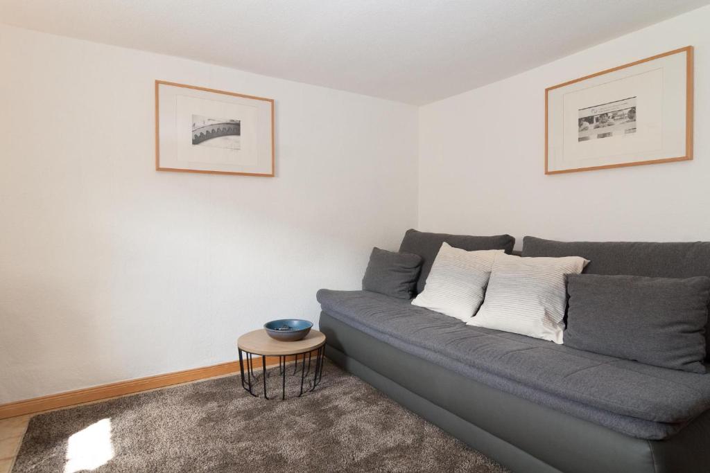 ein Wohnzimmer mit einem grauen Sofa und einem Tisch in der Unterkunft Haus Möwe 5/22 in Hörnum