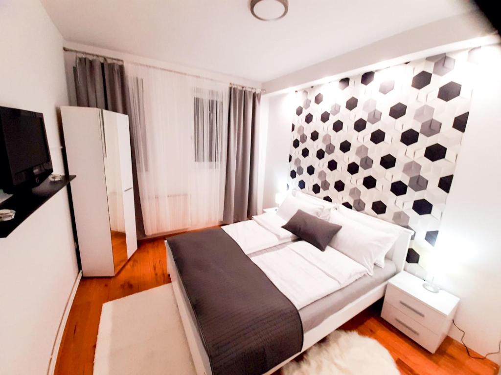 een slaapkamer met een bed en een muur met punten bij Apartman Djoana - dvosoban apartman u blizini Akva Parka Vrnjačke Terme in Vrnjačka Banja