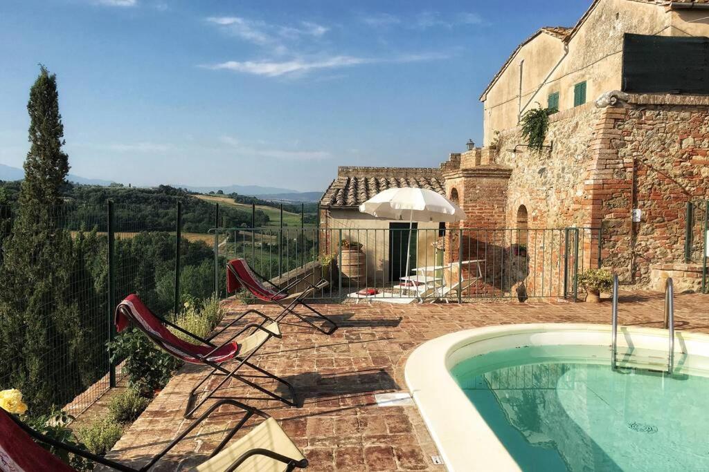 una piscina con 2 sillas y un edificio en La Capanna,piscina,vista,WiFi,in paese en San Giovanni dʼAsso