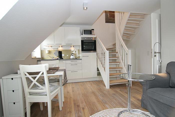 a kitchen with a staircase and a living room at Strandperle 03 in Hörnum