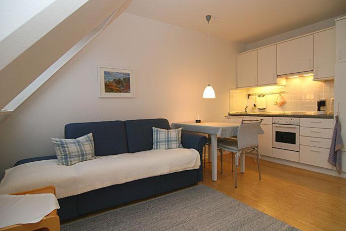 a living room with a bed and a kitchen at Ferienwohnung Filter in Hörnum