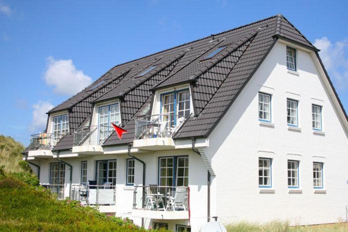 a large white house with a black roof at Ferienwohnung Filter in Hörnum