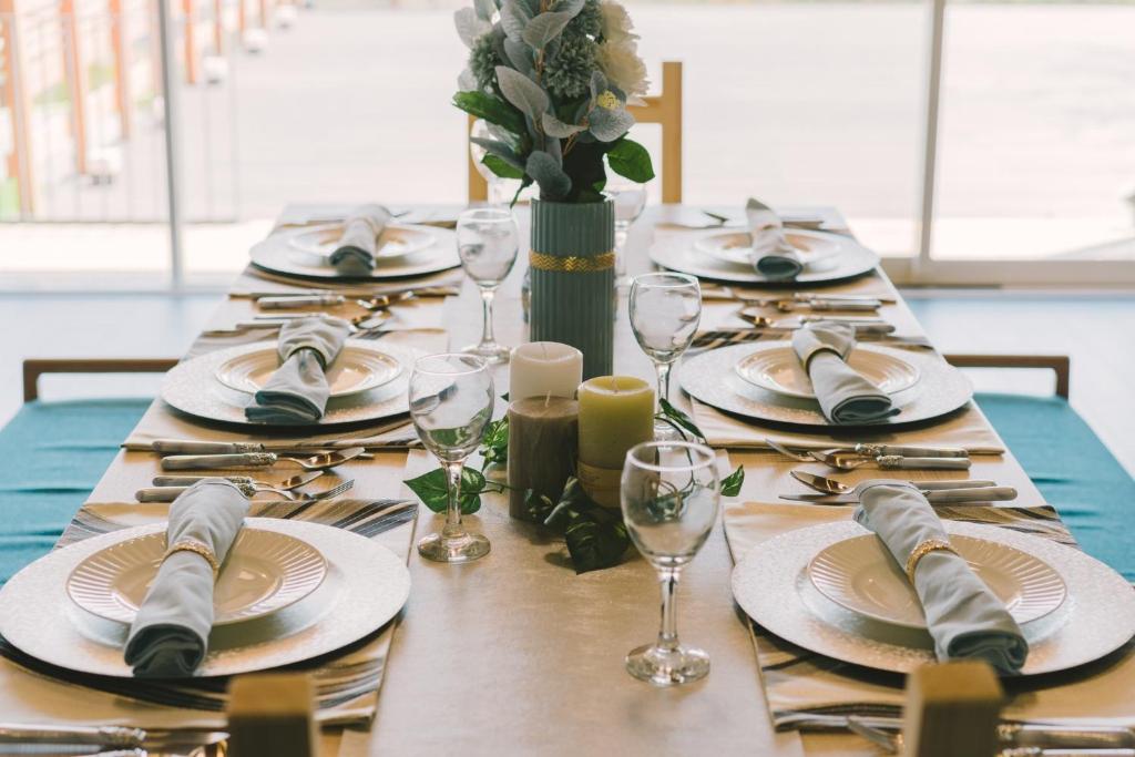 una mesa larga con platos y cubiertos en Blue Spring Villa - Vacation STAY 11143 en Kado