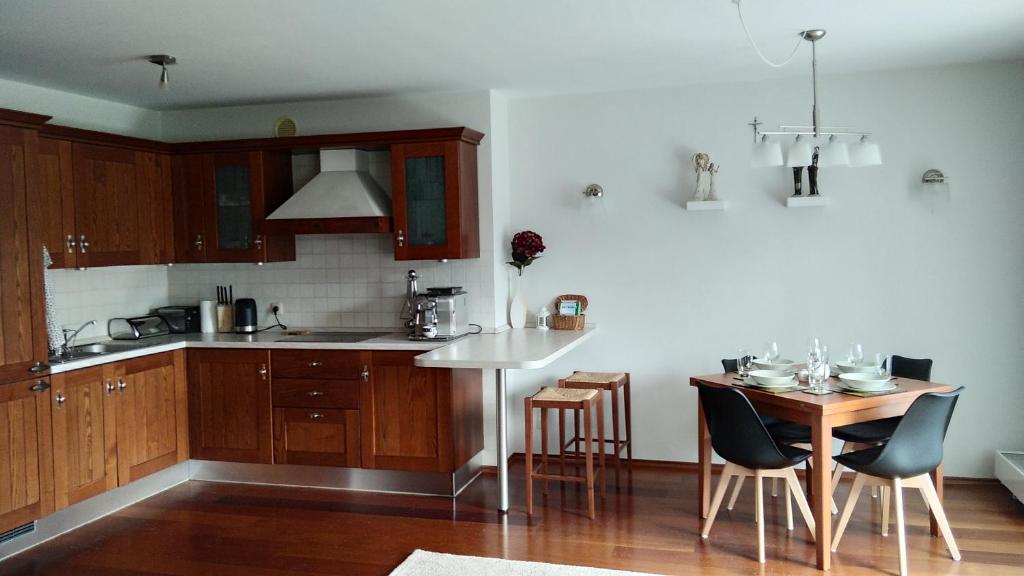 een keuken met houten kasten en een tafel met stoelen bij Antresola apartament Zeta Park in Ustroń