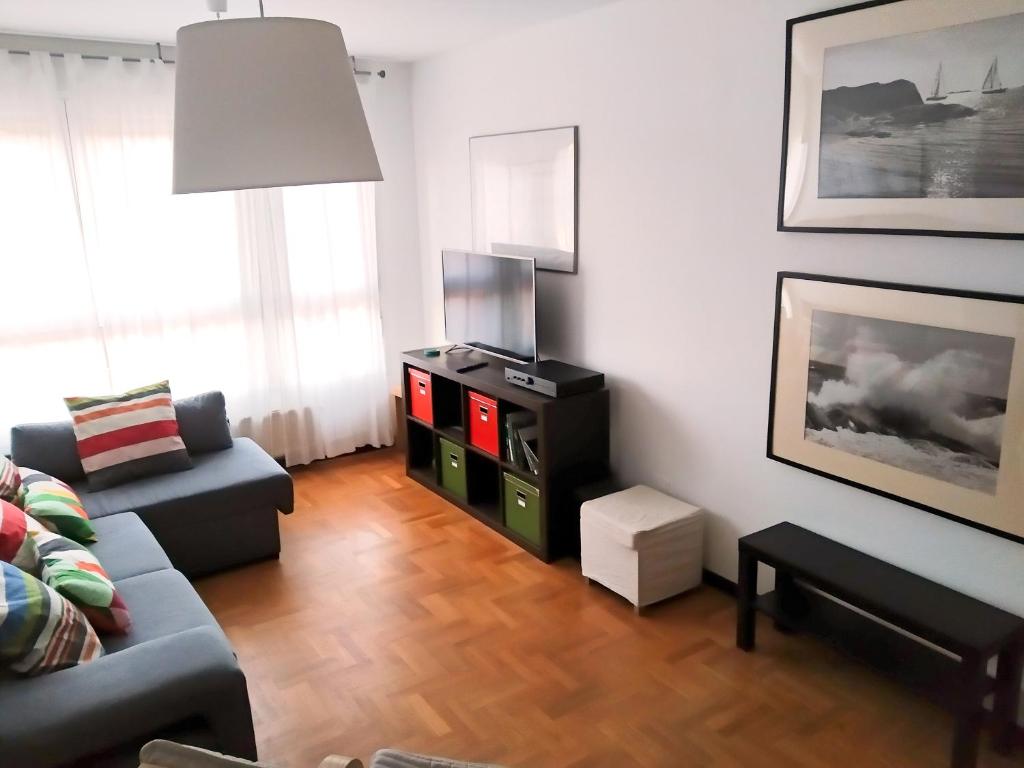 een woonkamer met een bank en een tv bij El Duplex Luanquino in Luanco