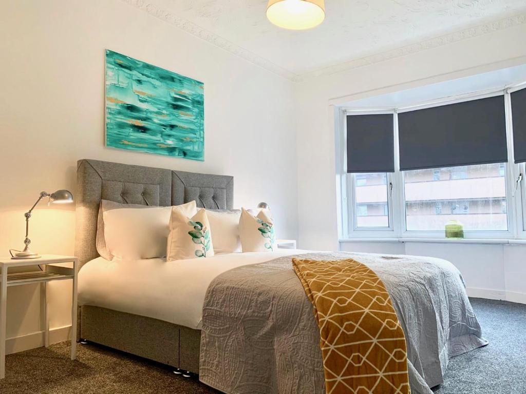 格拉斯哥的住宿－Hillington Central，卧室配有带枕头的床铺和窗户。