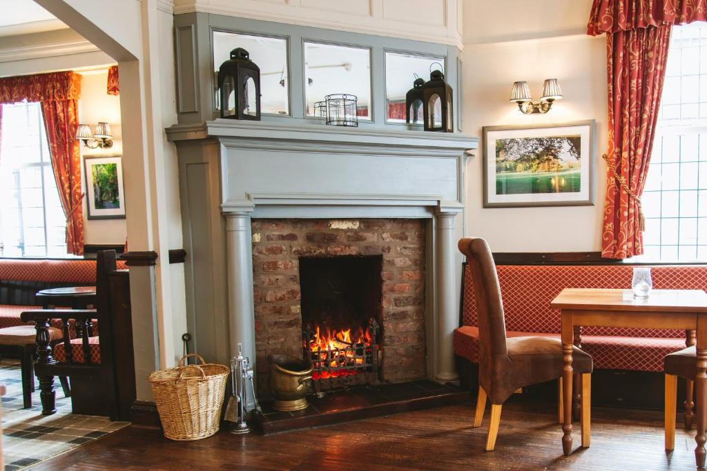 a fireplace in a restaurant with a fire place at The Bulls Head in Milnthorpe