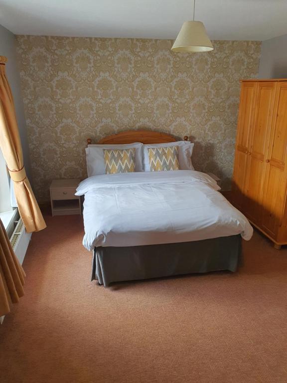 a bedroom with a large bed with a wooden headboard at Kesh self catering holiday home. in Kesh