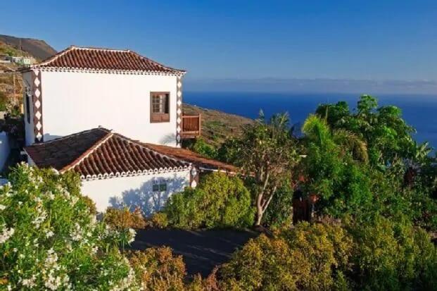 een wit huis op een heuvel naast de oceaan bij Casa La Gorona in Fuencaliente de la Palma