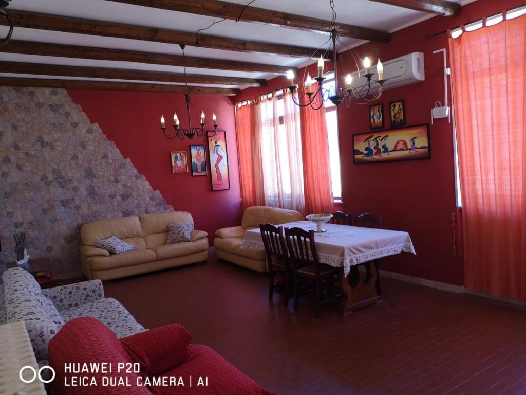 ein Wohnzimmer mit einem Tisch und einem Sofa in der Unterkunft La casa di nicola in Trapani