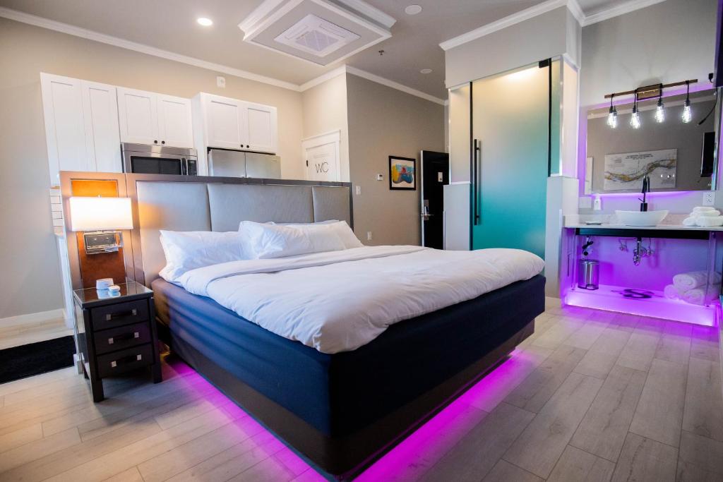 a bedroom with a large bed with purple lights at River Sirens Hotel in Washington